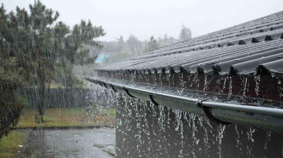 L'eau de pluie ruisselle abondamment le long d'une toiture et de sa gouttière lors d'une averse, constituant la première étape indispensable d'une installation plomberie ecologique eau de pluie.