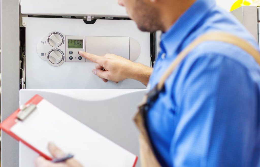 Un technicien qualifié effectue un contrôle dans le cadre de la réglementation sécurité chauffage au gaz.