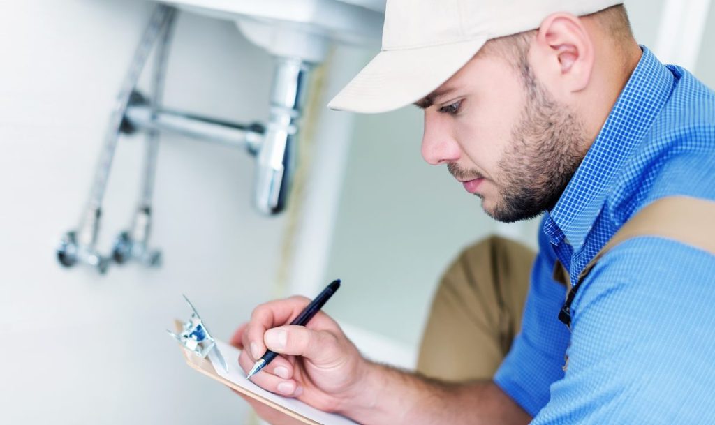 Technicien remplissant une grille d'audit pour le certificat de conformité installation chauffage gaz validité